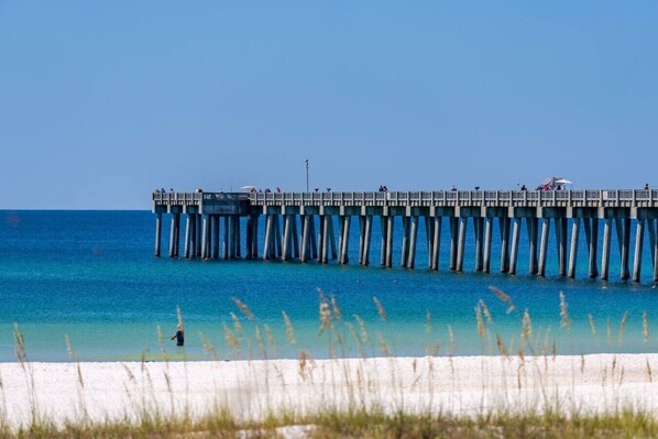 A pier extending into the water with a clear sky above. - Steps To Beach Access 45 & Salty Goat Saloon (Panama City Beach)
