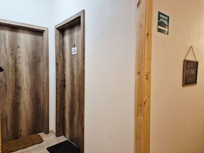 Ein Flur mit zwei Holztüren, einem Schild mit der Aufschrift 'H&K Apartments' und einem Schild für 'WiFi AP Unif'.