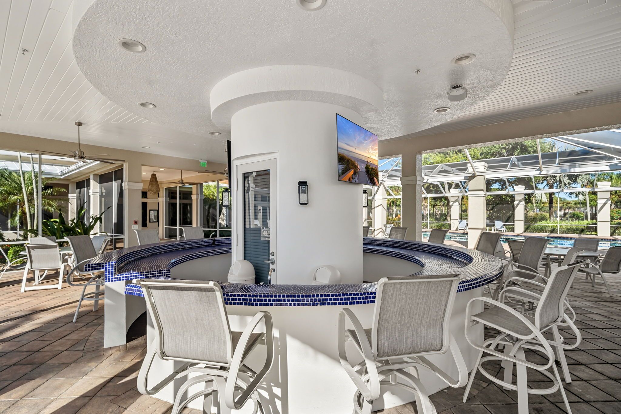 A poolside bar area with a circular seating arrangement and a view of the pool.