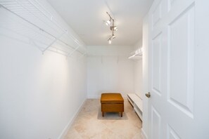 A hallway with a bench, a door, and a ceiling light fixture.