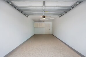 A hallway with a ceiling fan, a door at the end, and a light fixture. - Newly Remodeled Naples Retreat - Resort-Style Living at Bridgewater Bay (Naples)