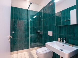 A modern bathroom with a glass shower enclosure, a white sink, and a toilet. - ZH Green 3 - Letzigrund HITrental Apartment by Interhome (Zurich)