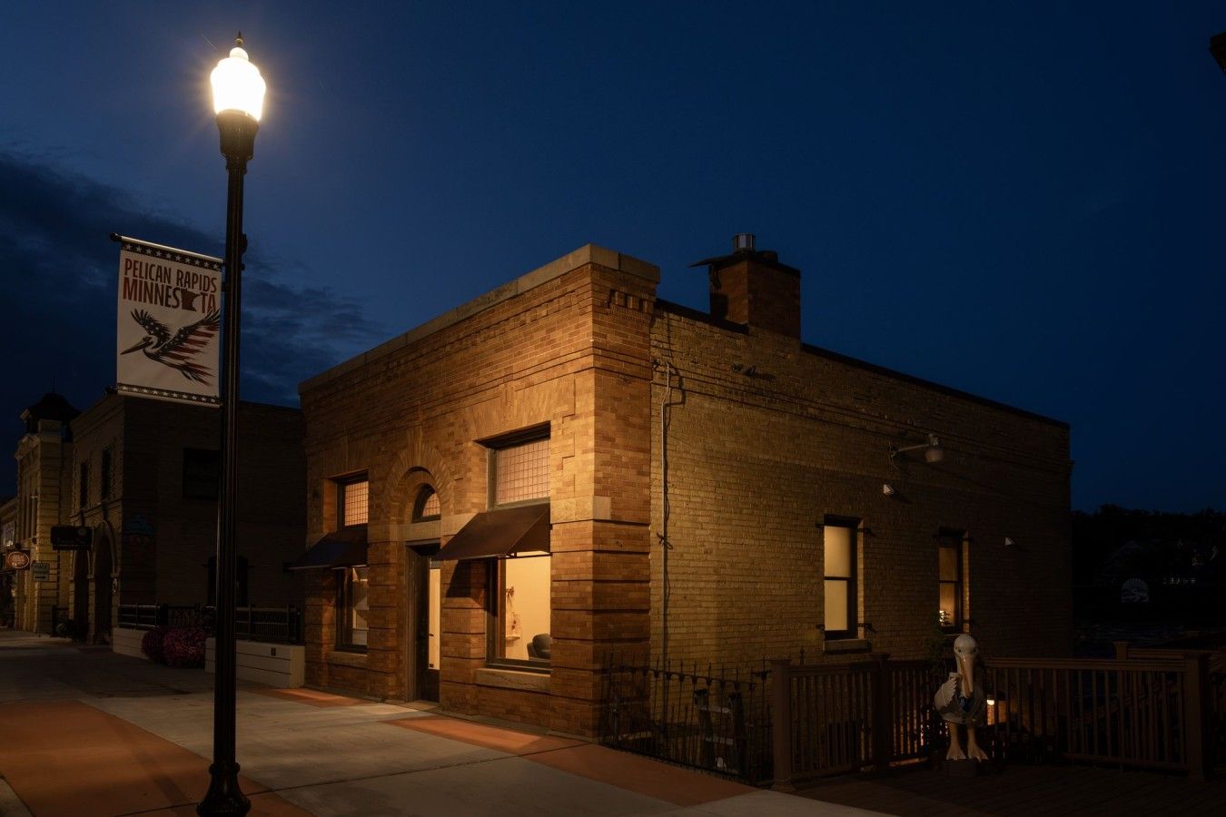 A brick building with a street lamp and a sign.