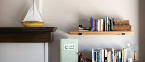 A bookshelf with books and a small figurine.