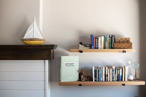 Una estantería con libros y una pequeña figurita.