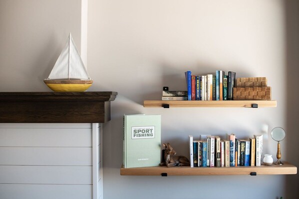 Una estantería con libros y una pequeña figurita.