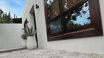 Ein modernes Gebäude mit großem Fenster und einem Schotterweg.