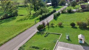 A rural landscape with a paved road, green fields, and scattered trees. - Les Gîtes du Gore Virat, (Corcelles BE), by Interhome (Corcelles)