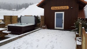 A wooden cabin with a sign reading 'Gites du Gore-Viral' and a hot tub in the foreground. - Les Gîtes du Gore Virat, (Corcelles BE), by Interhome (Corcelles)