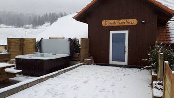 Une cabane en bois avec une enseigne indiquant « Gîtes du Gore-Viral » et un jacuzzi en premier plan.