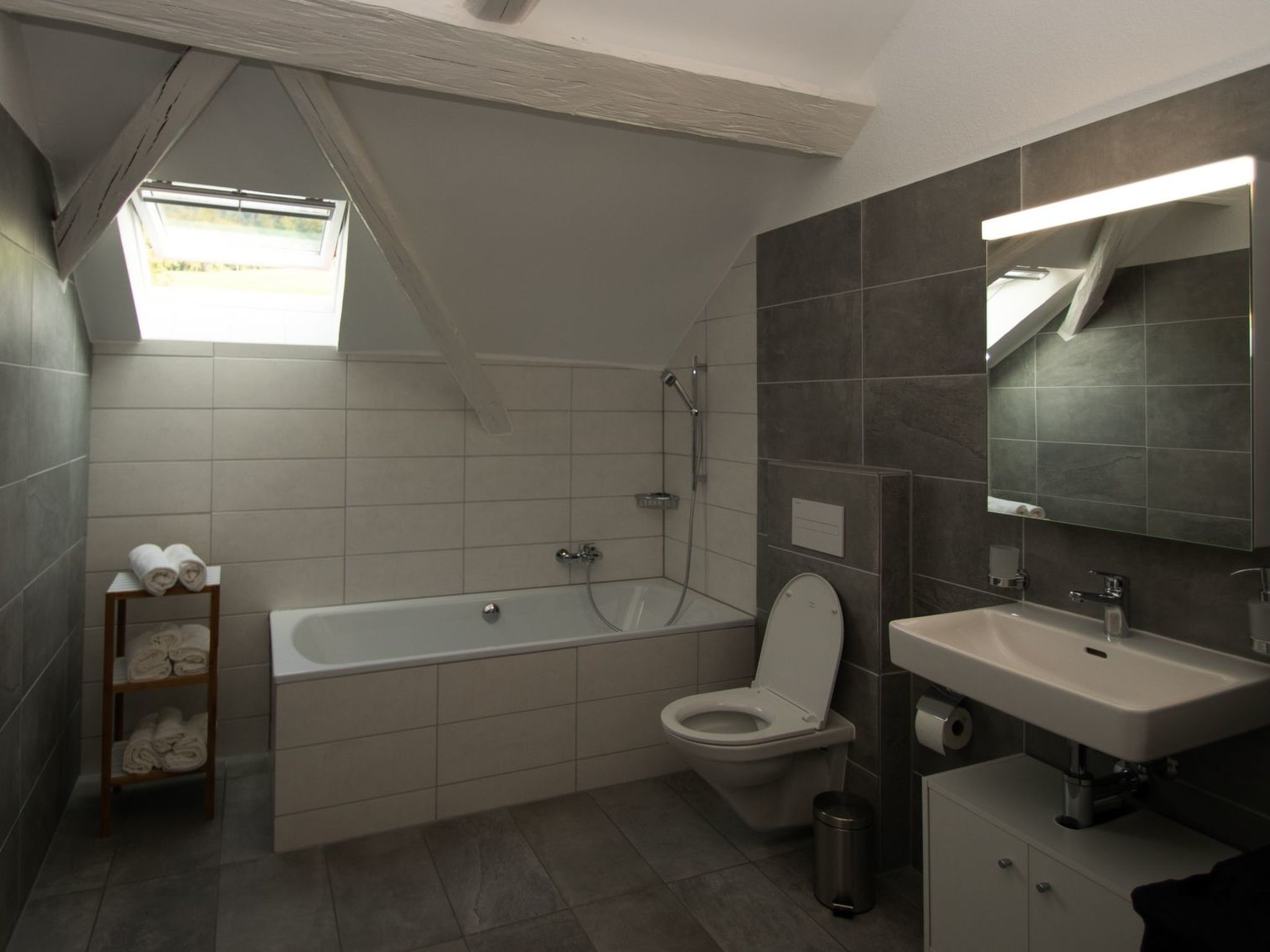 Ein modernes Badezimmer mit Badewanne, Toilette und Waschbecken.