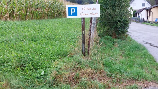 Een parkeersbord met een blauwe 'P' en tekst in een vreemde taal, dat een parkeerplaats aangeeft.