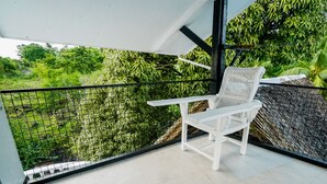 A white chair on a balcony with a view of greenery. - Watson Residence w/Private pool, Billiards, and Tennis Court (Central Visayas)