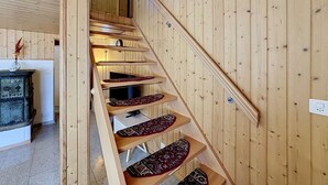 Una escalera de madera con barandilla que lleva a un piso superior.