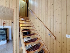 Eine Holztreppe mit Handlauf, die zu einer oberen Etage führt.