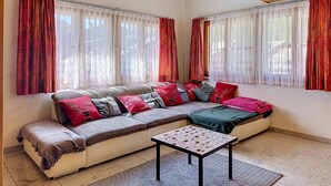 Una sala de estar acogedora con un sofá, una mesita y un techo con vigas de madera.