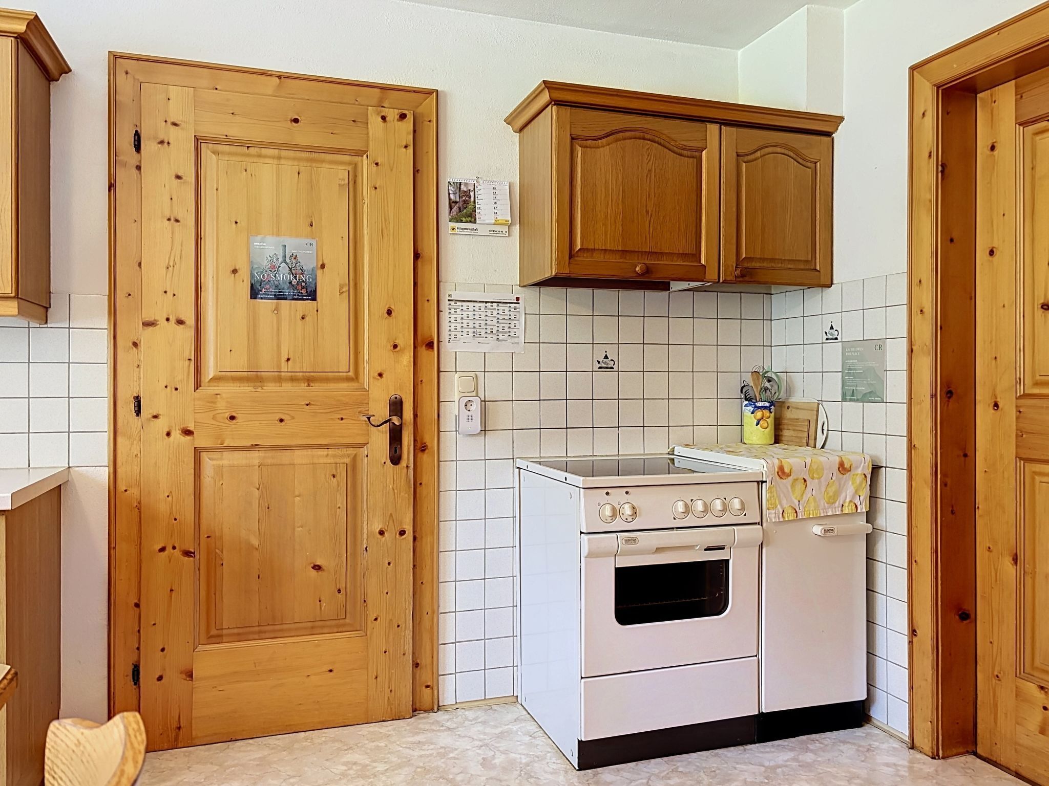 A kitchen with wooden cabinets, a white stove, and tiled walls.