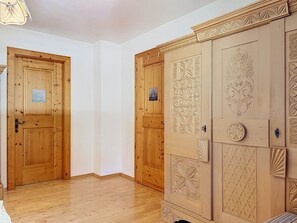 A room with wooden doors, a wardrobe with decorative panels, and a light fixture. - Resimini by Interhome (Pettneu am Arlberg)