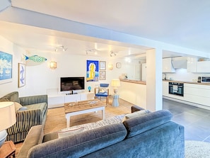 A modern living room with a sofa, TV, and artwork. - La Petite Maison du Golfe by Interhome (Le Bono)