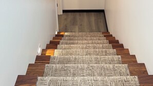 Un escalier avec des marches en bois et une plateforme recouverte de moquette.