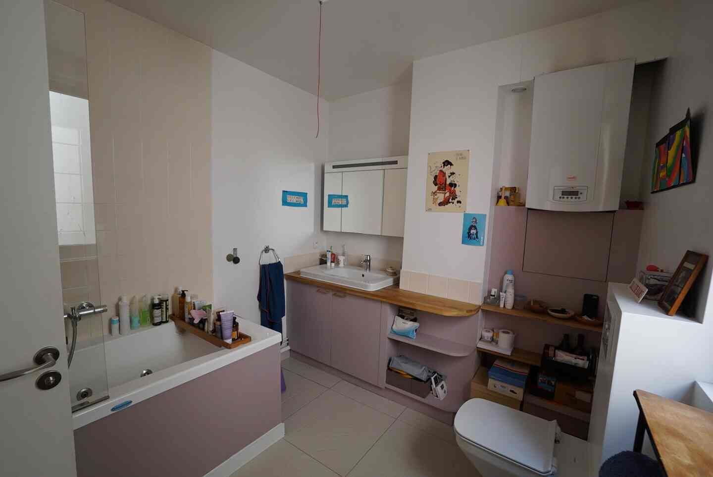 A bathroom with a bathtub, sink, toilet, and a mirror.