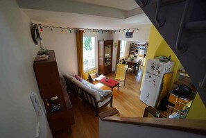 A multi-level living space with a sofa, dining table, and kitchen area. - Bright apartment with a view of all of Paris, 5 rooms, 3 levels, feels like a house, Belleville (Paris)