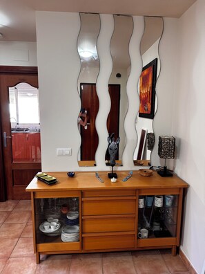 A wooden cabinet with glass doors, a mirror, and decorative items. - 4-bedroom house in a gated community with a pool and beaches just 5 minutes away (Alcalà de Xivert)