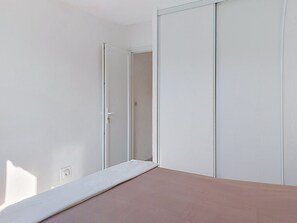 A room with a bed, a door, and a closet. - Les Nouvelles Mirandas by Interhome (Saint Cyprien)