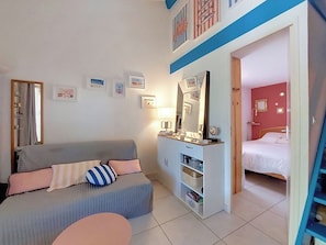 Ein Schlafzimmer mit Bett, Sofa, Kommode und Spiegel.