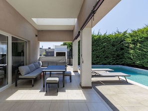 A modern outdoor patio with a pool, a sofa, a table, and chairs. - Vacation home A.E.M by Interhome (Medulin/Šišan)