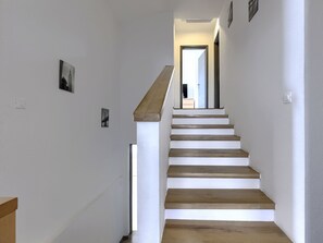 A staircase with wooden steps and white walls, leading to a room with a door and a window. - Vacation home A.E.M by Interhome (Medulin/Šišan)
