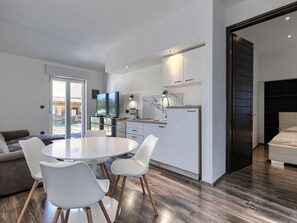 A modern kitchen with white cabinets, a built-in oven, and a flat-screen TV. - Vacation home A.E.M by Interhome (Medulin/Šišan)