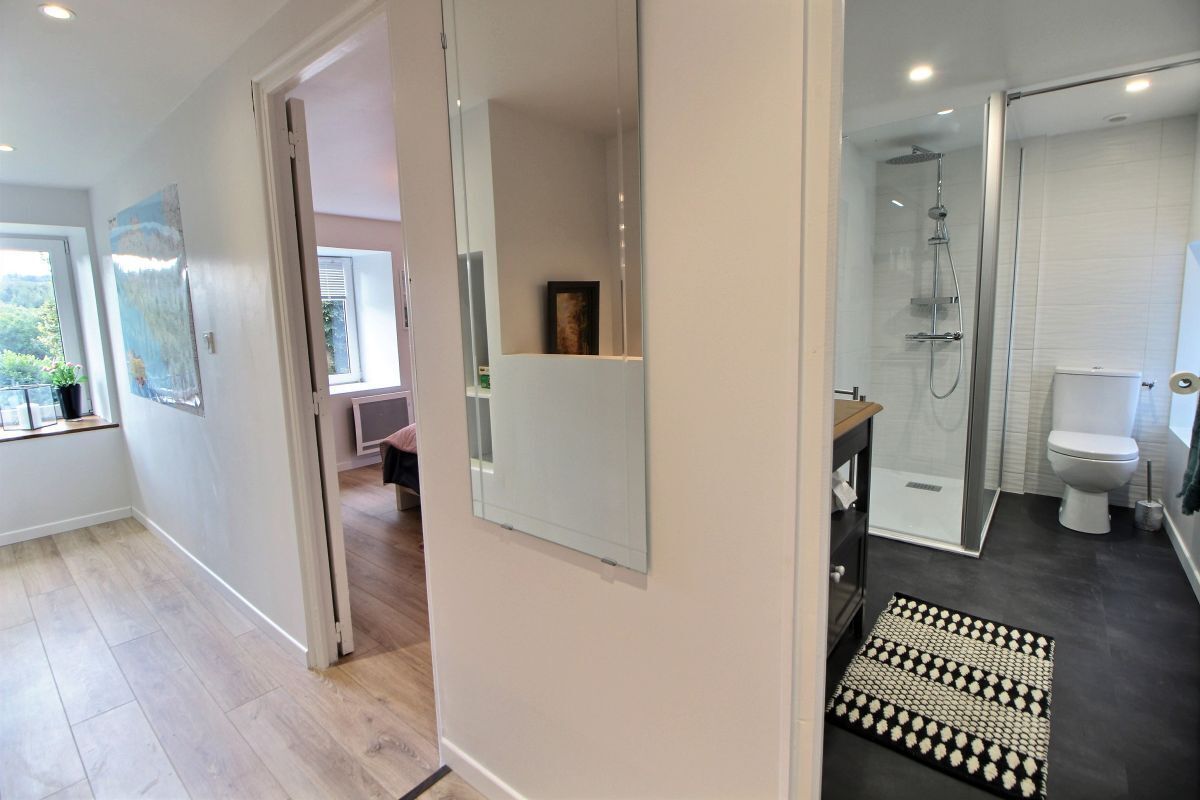 A modern bathroom with a shower, toilet, and a glass-enclosed shower area.
