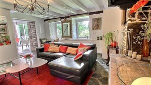 Ein Wohnzimmer mit einem Ecksofa, einem kleinen Tisch und einem Kamin.
