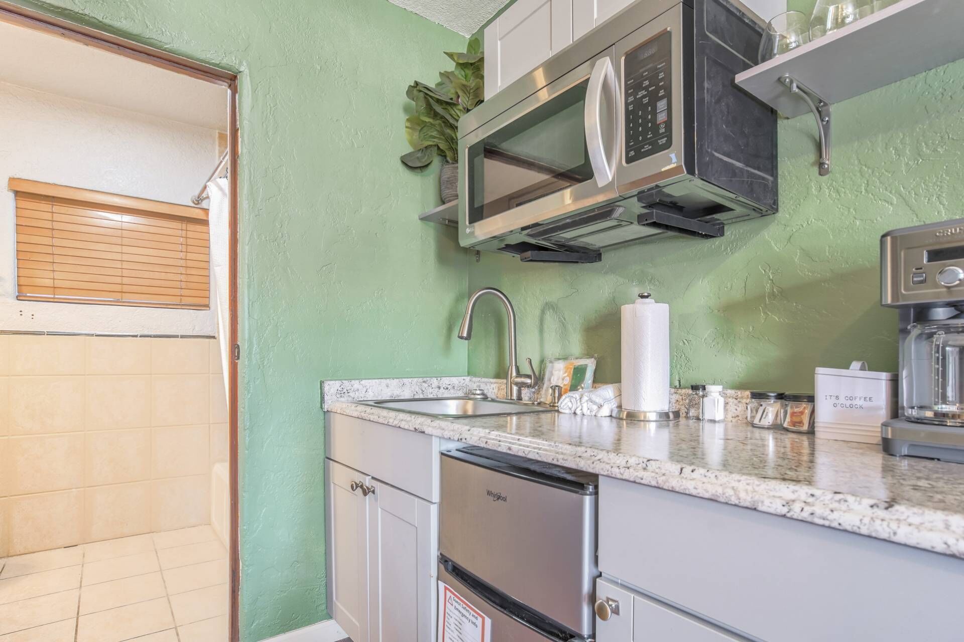 A kitchen with a built-in microwave, a sink, and a dishwasher.