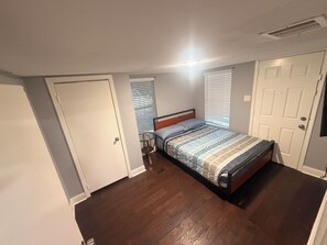 Ein Schlafzimmer mit einem Bett, einem kleinen Tisch und einer Tür.