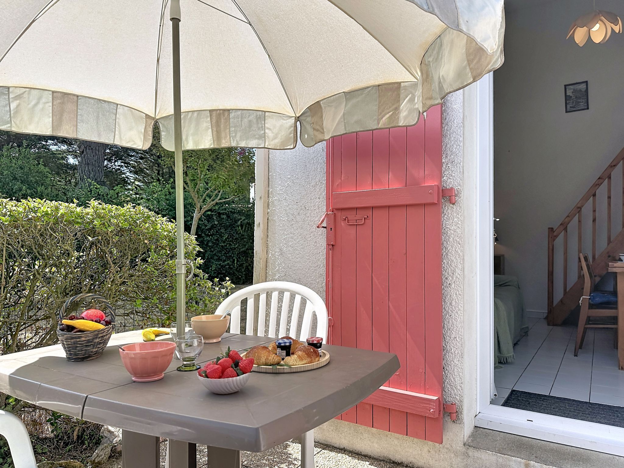 An outdoor dining area with a table, chairs, and an umbrella.