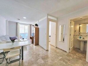 Ein modernes Apartment mit Essbereich, einem Schlafzimmer mit Blick und einem Badezimmer mit Waschbecken und Spiegel.