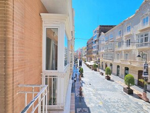 A narrow street with buildings on both sides, a tiled pavement, and a few pedestrians. - Apartamento Alba 6 by Interhome (Cartagena)