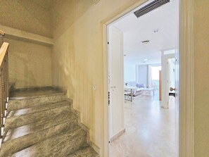 A staircase leading to a room with a bed, a table, and a chair. - Apartamento Alba 7 by Interhome (Cartagena)