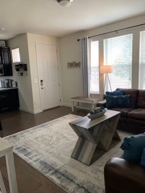 Ein Wohnzimmer mit modernem Couchtisch, einer Couch und einer Lampe.