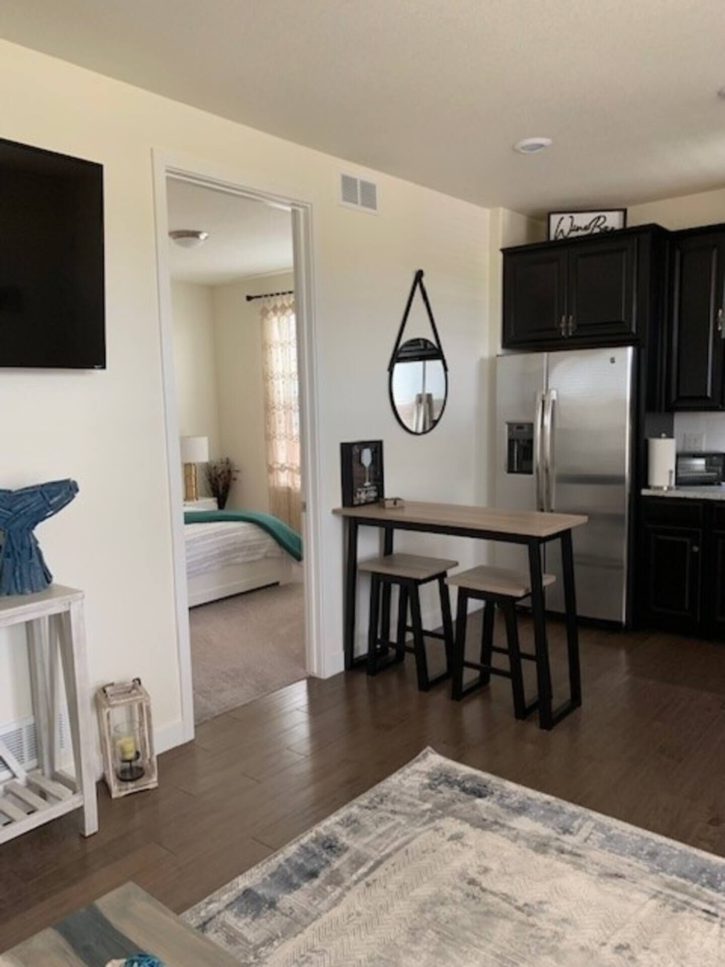 A compact living space with a kitchenette, a dining area, and a bedroom.