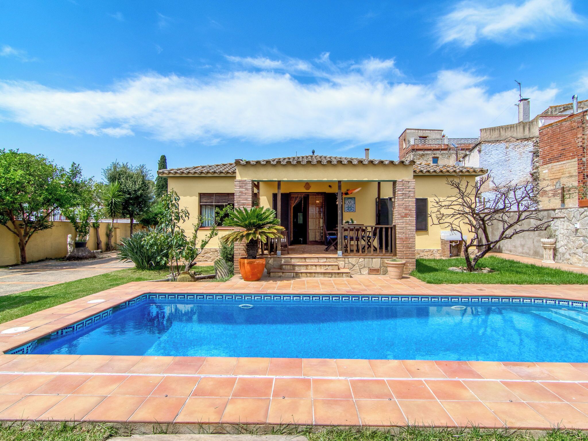 A residential property with a swimming pool, a patio area, and a garden.
