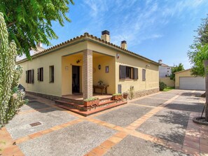 A two-story house with a tiled patio, a chimney, and a door leading to the entrance. - Sunrise by Interhome (Vilajuiga)