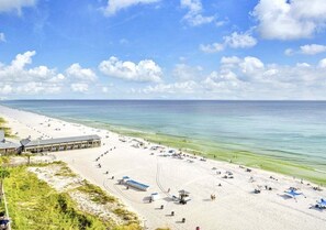 Ein Strand mit einer langen Seebrücke, feinem Sand und blauem Himmel.