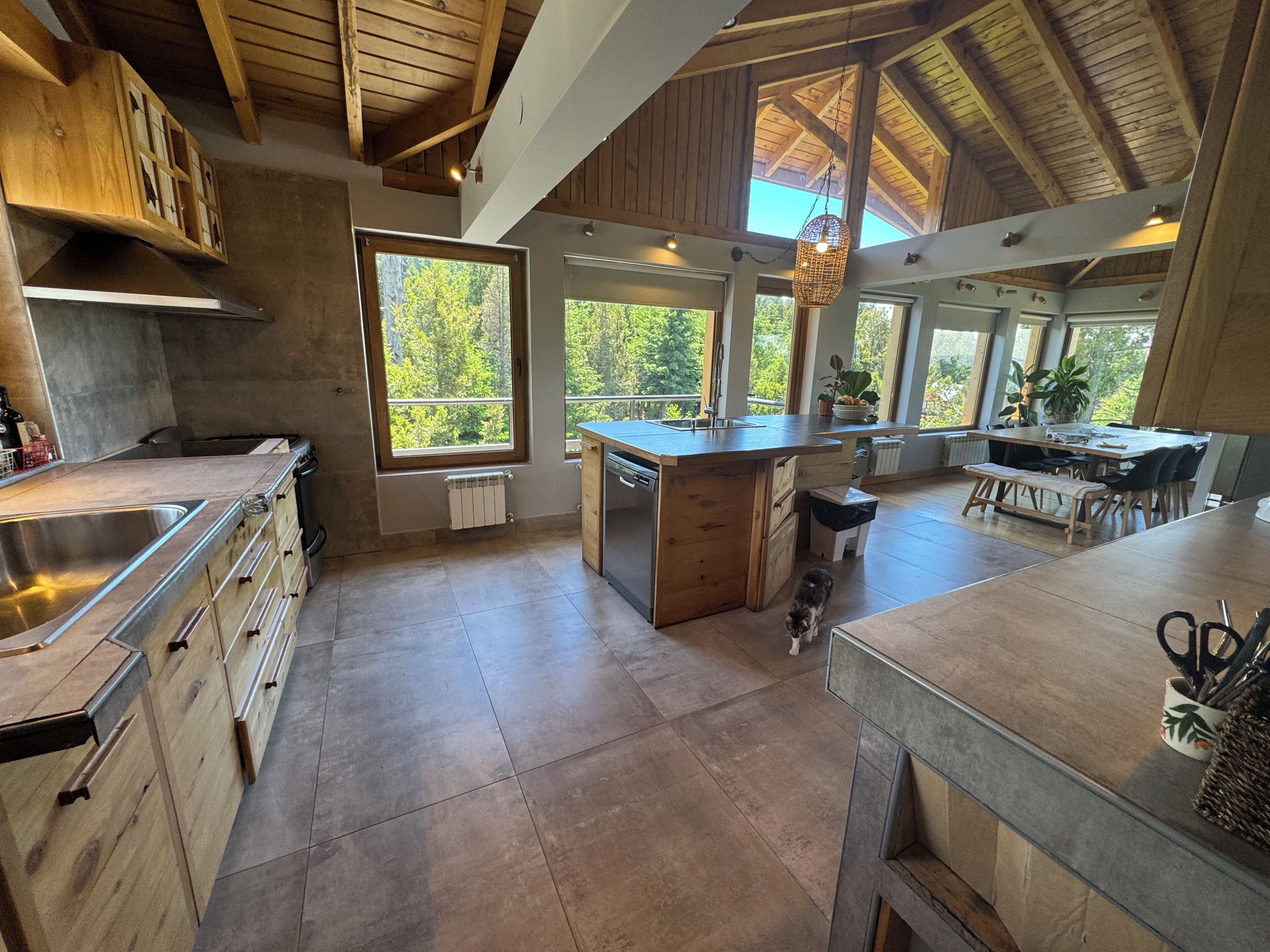 Una cocina amplia con una isla grande, armarios de madera y vistas al exterior.