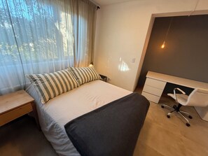 A bedroom with a bed, a desk, and a chair. - House of Worship (San Carlos de Bariloche)