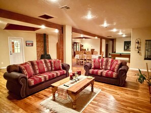 A living room with two sofas, a coffee table, and a dining area in the background. - Charming Southwest Hacienda 4Br/4.5Ba (Anthony)