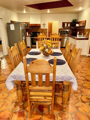 A dining area with a table set for six, surrounded by wooden chairs with cushioned seats. - Charming Southwest Hacienda 4Br/4.5Ba (Anthony)