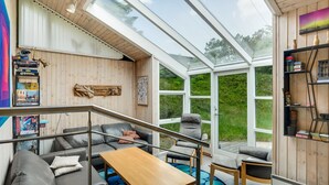 A modern interior with a glass ceiling, grey sofas, a wooden table, and a blue patterned rug. - "Nikoletta" - 150m from the sea by Interhome (Fjerritslev)